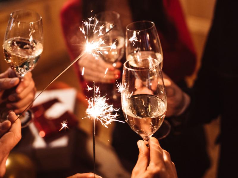 Folk skåler nytåret ind med champagne.